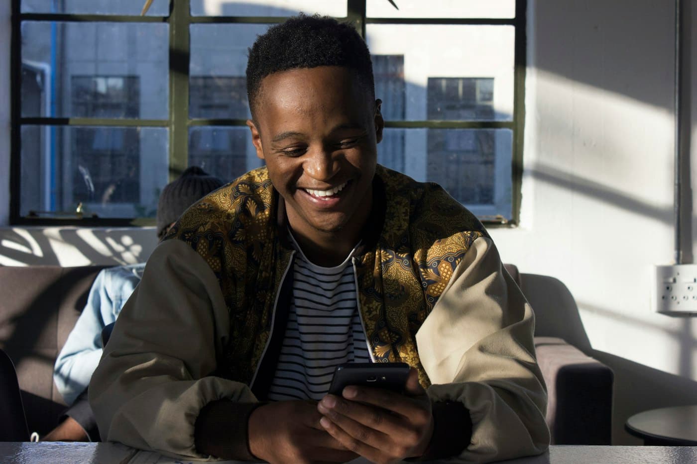 Man smiling while using his smartphone